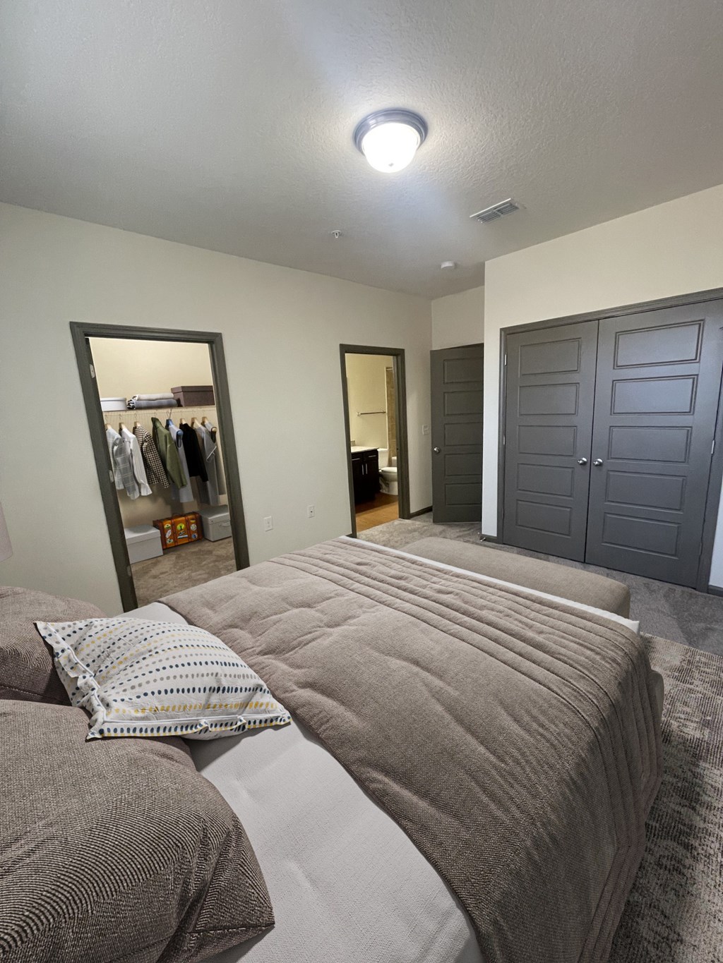 A bedroom with a bed, a wardrobe, and a mirror.