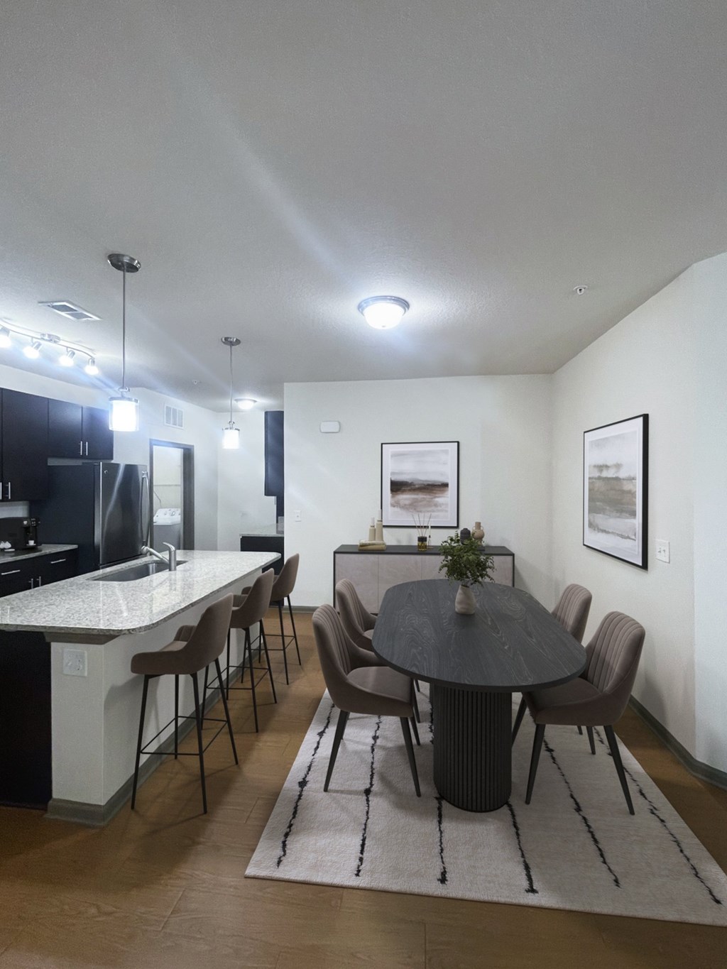 A modern dining room with a round table and chairs.