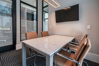 a conference room with a marble table and chairs at Altis Twin Lakes Apartments, Kissimmee
