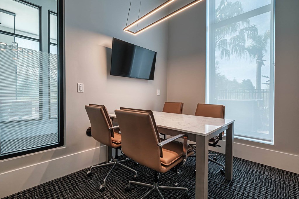 a conference room with a table and chairs and a tv