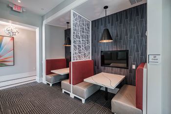 a living room with two tables and chairs and a television at Altis Twin Lakes Apartments, Kissimmee, 34744