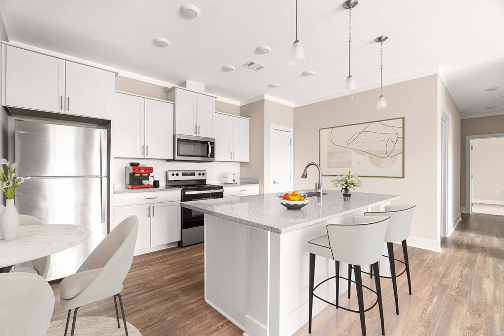 A modern kitchen with a white island and bar stools.
