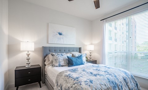 a bedroom with a bed and a large window