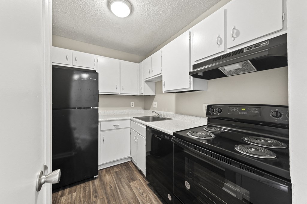 the preserve at ballantyne commons apartment kitchen with black appliances and white cabinets