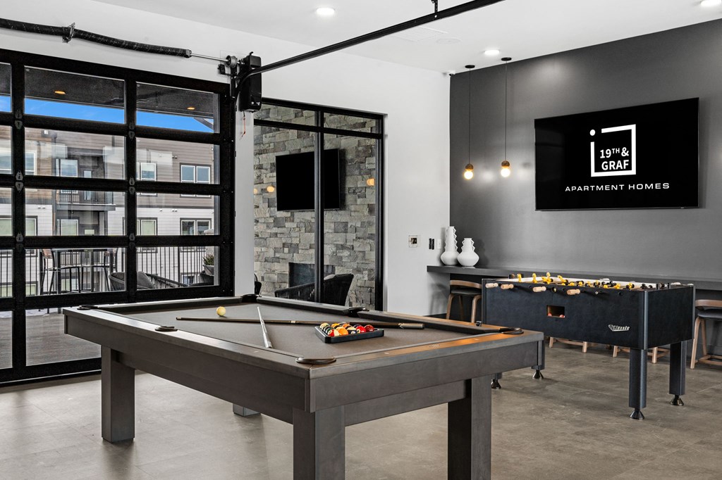 A pool table in a room with a TV and a fireplace.