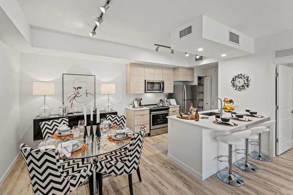 a kitchen and dining area with a dining table and chairs at Altis Grand Lake Willis, Orlando, FL
