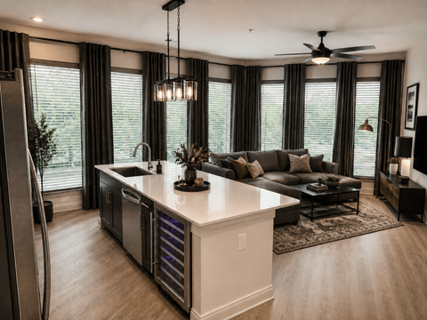 A modern kitchen with a large island and a refrigerator on the left.