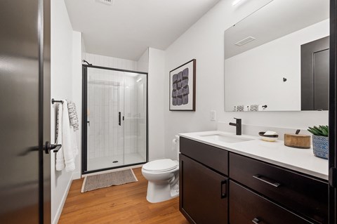 a bathroom with a toilet sink and shower in a 555 waverly unit