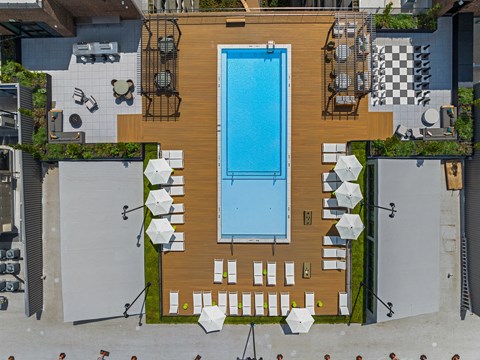 arial view of a resort style pool with lounge chairs and umbrellas