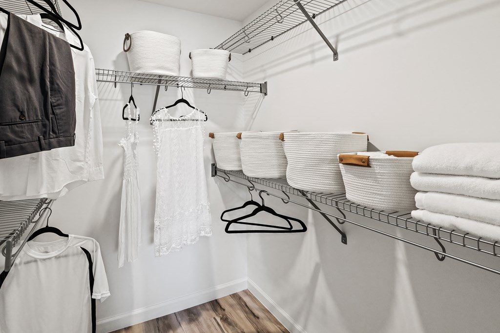 a walk in closet with baskets of clothes and rails for hangers at Altis Grand Lake Willis, Florida