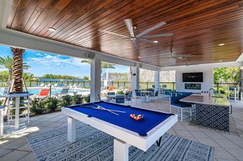 a pool table in a covered patio with a view of a pool at Altis Grand Suncoast, Florida