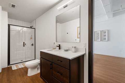 a bathroom with white walls and a wooden floor