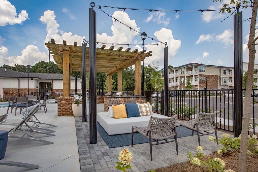 a patio with a couch and chairs and a pergola
