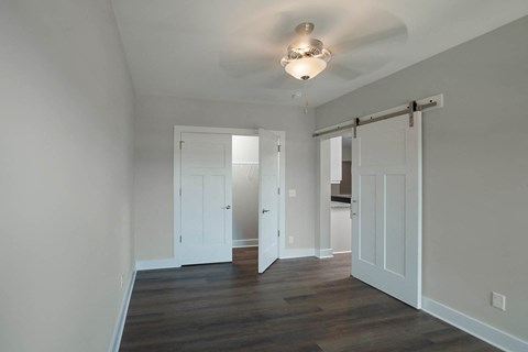 a living room with white walls and white doors and a ceiling fan