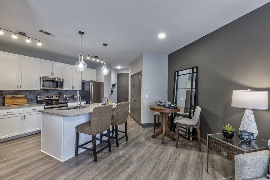an open kitchen and living room with a dining room table and chairs