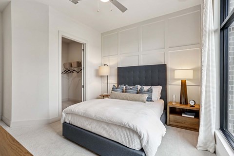 A bedroom with a large bed and a ceiling fan.