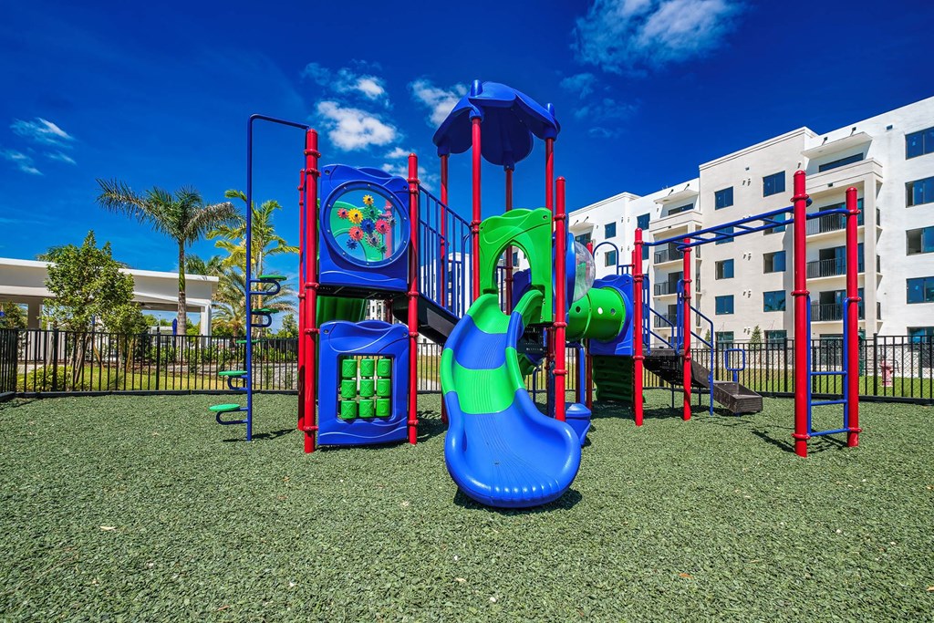 a playground with a slide and other play equipment in front of a building