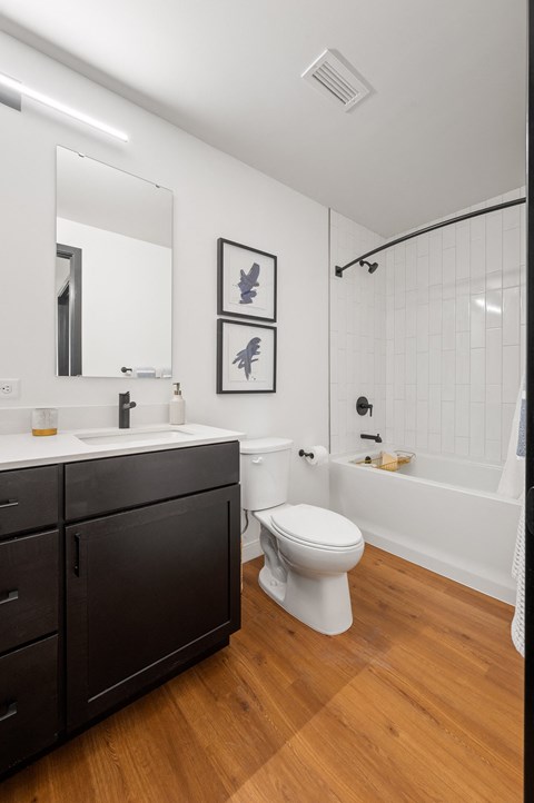 a bathroom with white walls and a wooden floor