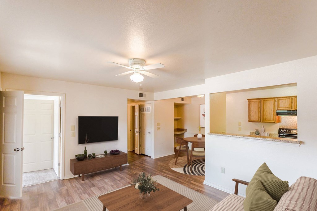 the view of a living room and kitchen with a ceiling fan