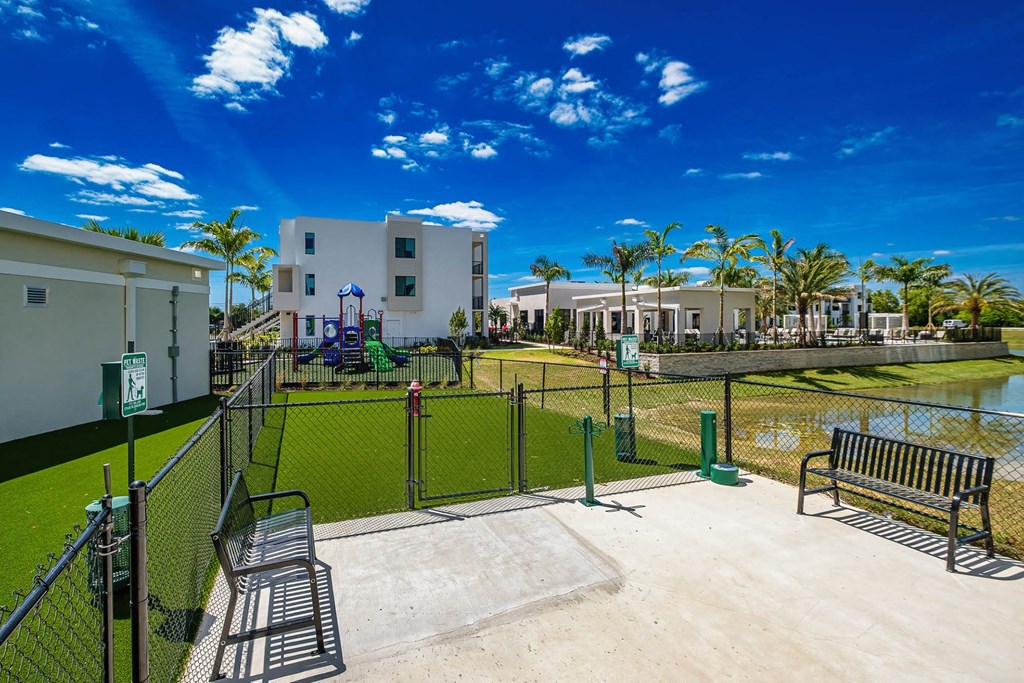 a fenced in area with a tennis court and benches