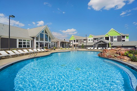 A large swimming pool in front of a building with a green roof.