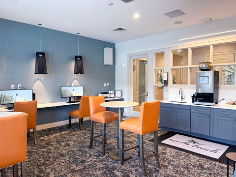 A modern kitchen with orange chairs and a grey cabinet.