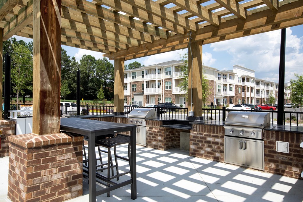 Three BR Apartments in Norcross, GA - The Darnell - Covered Grill Area with Two BBQs, Counter Space, and Bar Table with Stools