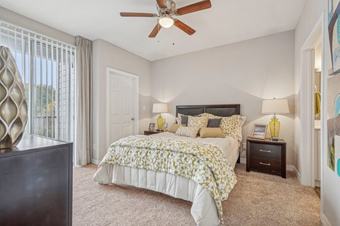 A bedroom with a large bed and a ceiling fan.