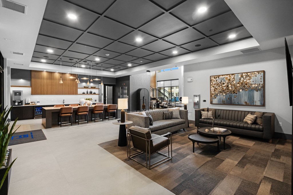 A modern living room with a variety of seating options and a large painting on the wall.