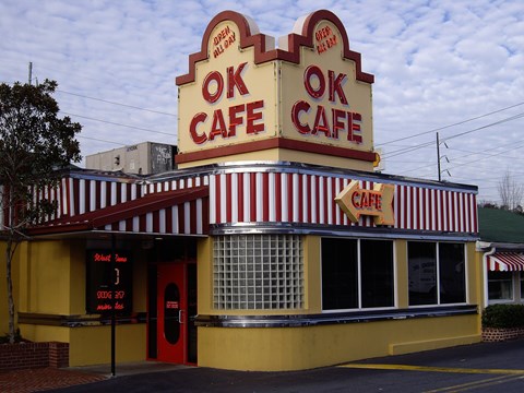 A yellow and red striped building with the words "OK CAFE" on top.