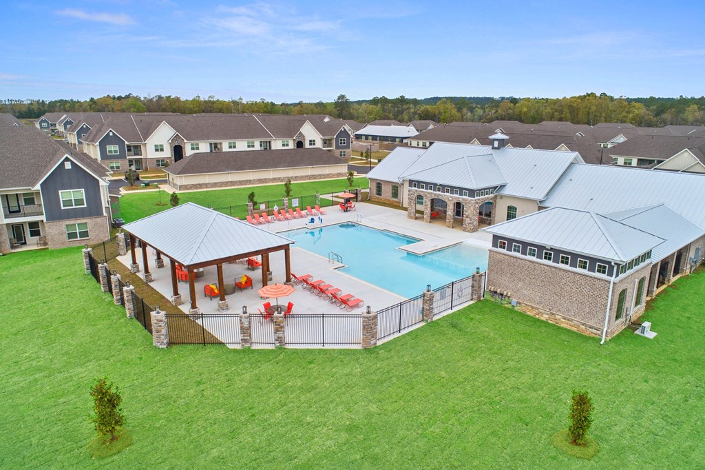 an aerial view of an outdoor pool with buildings in the background