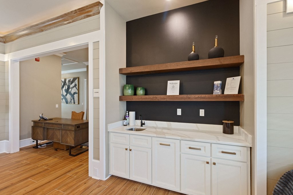 a rendering of a kitchen with white cabinets and a wood floor