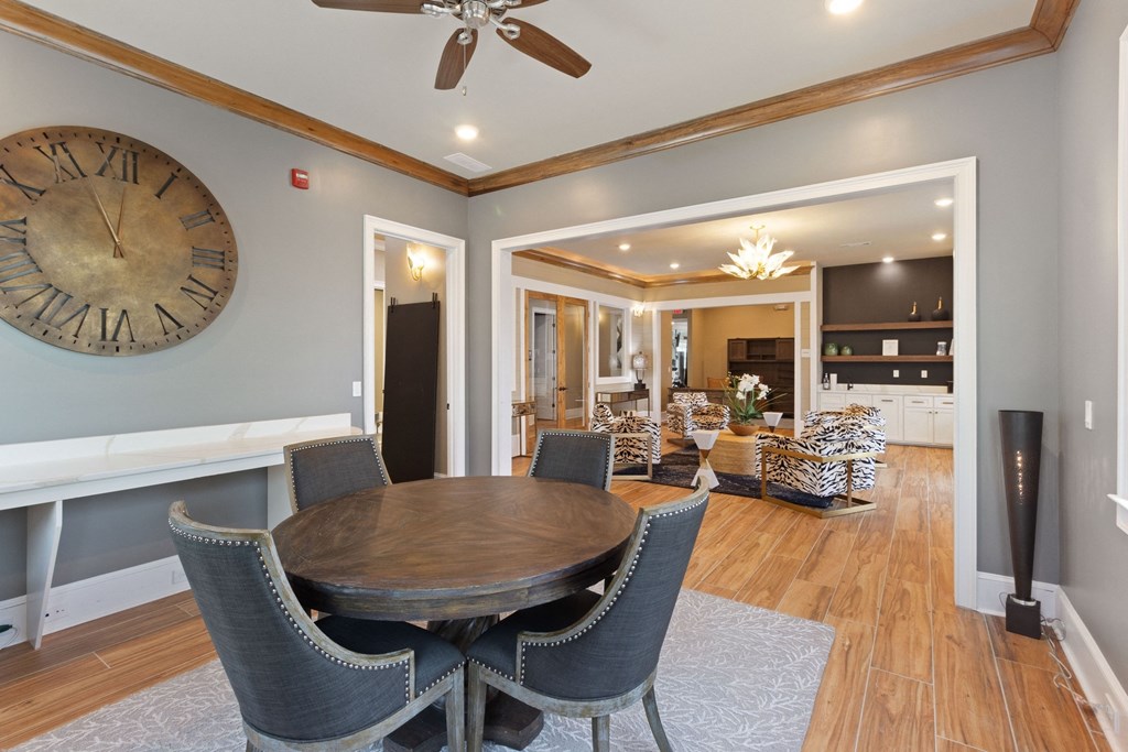 a dining room with a large clock on the wall and a dining table