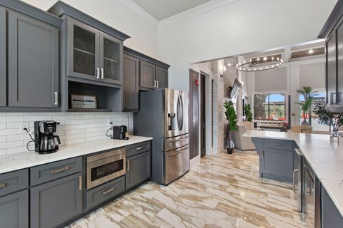 a kitchen with gray cabinets and a marble floor