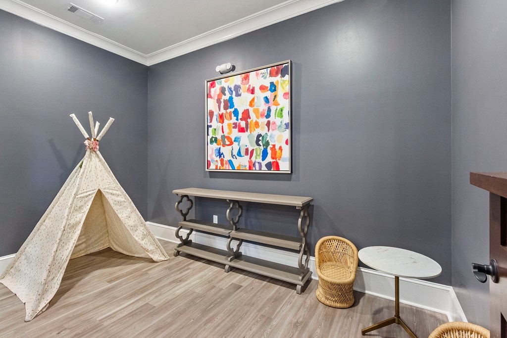 a play room with a teepee and a painting on the wall