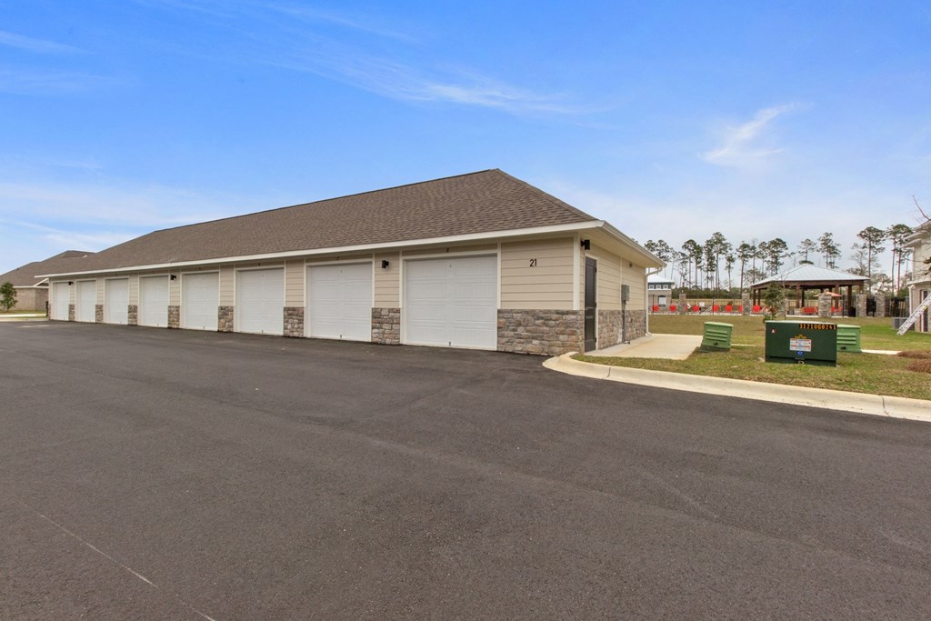 a building with white garage doors on the side of a road