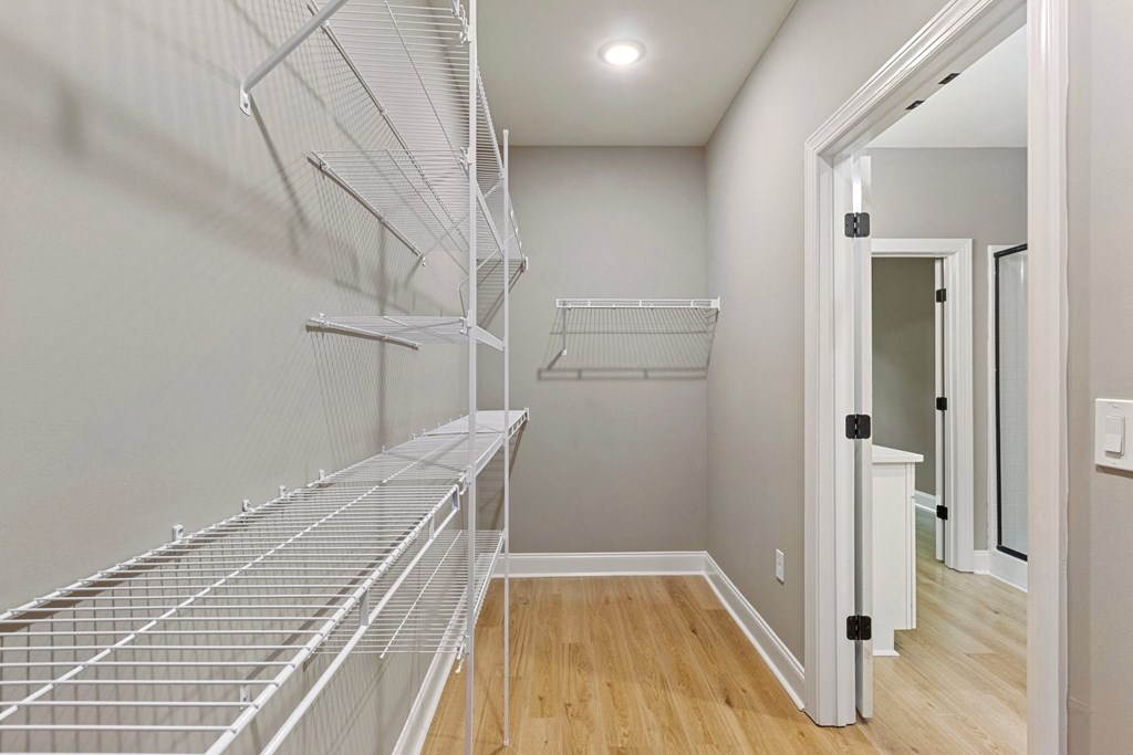 the walk in closet in a new home with a mirrored closet door