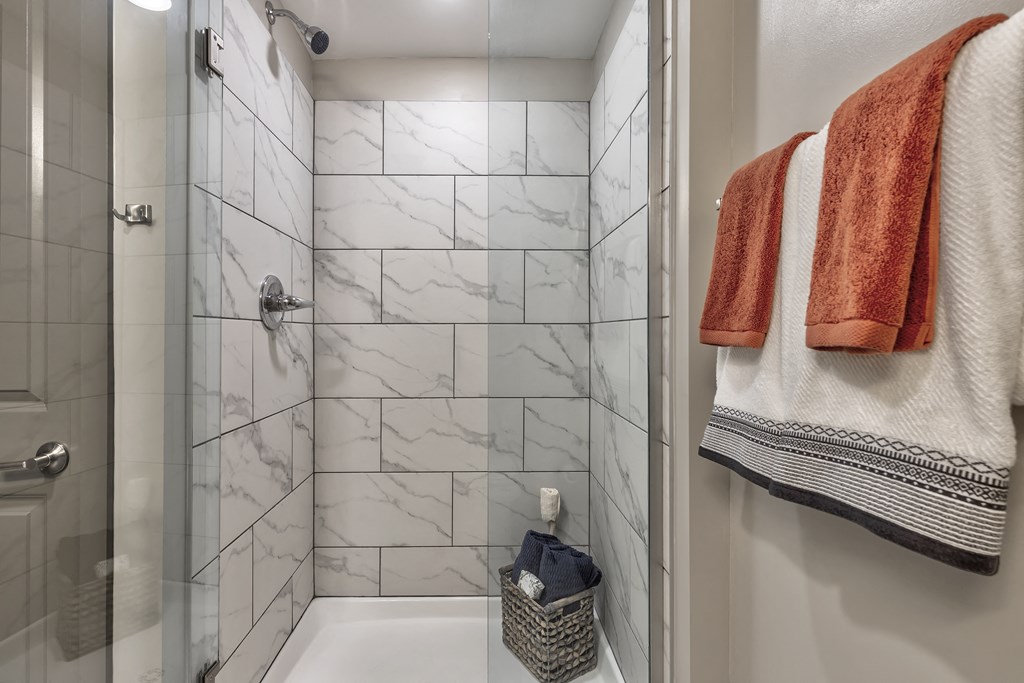 a shower with two towels and a sink in a bathroom