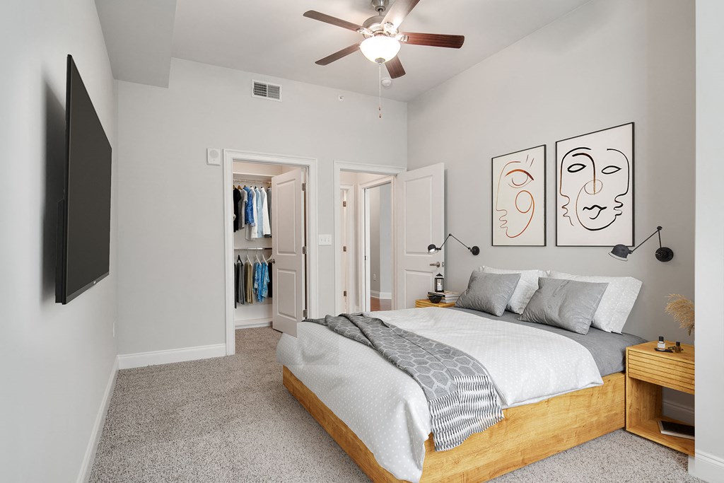 Luxury Apartments Near Phipps Plaza In Buckhead, GA - 92 West Paces - Bedroom With Plush Carpeting, Ceiling Fan, And A Spacious Closet With Storage Shelves & Hanging Racks.