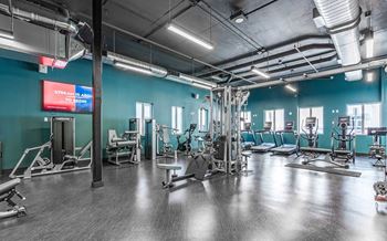 A gym with a variety of equipment and a sign that says "Stream Away To Become".