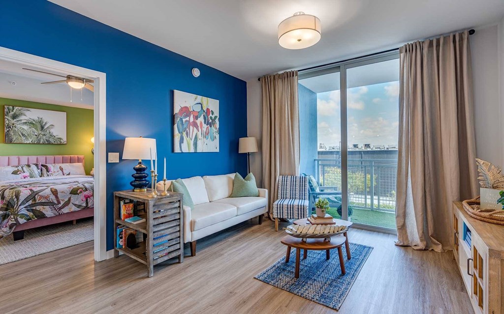 A living room with a blue wall and a white couch.