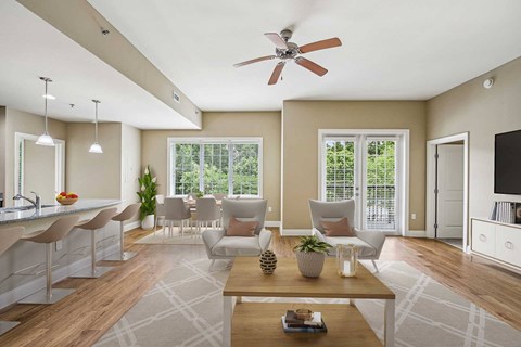 A living room with a ceiling fan and a dining table with chairs.
