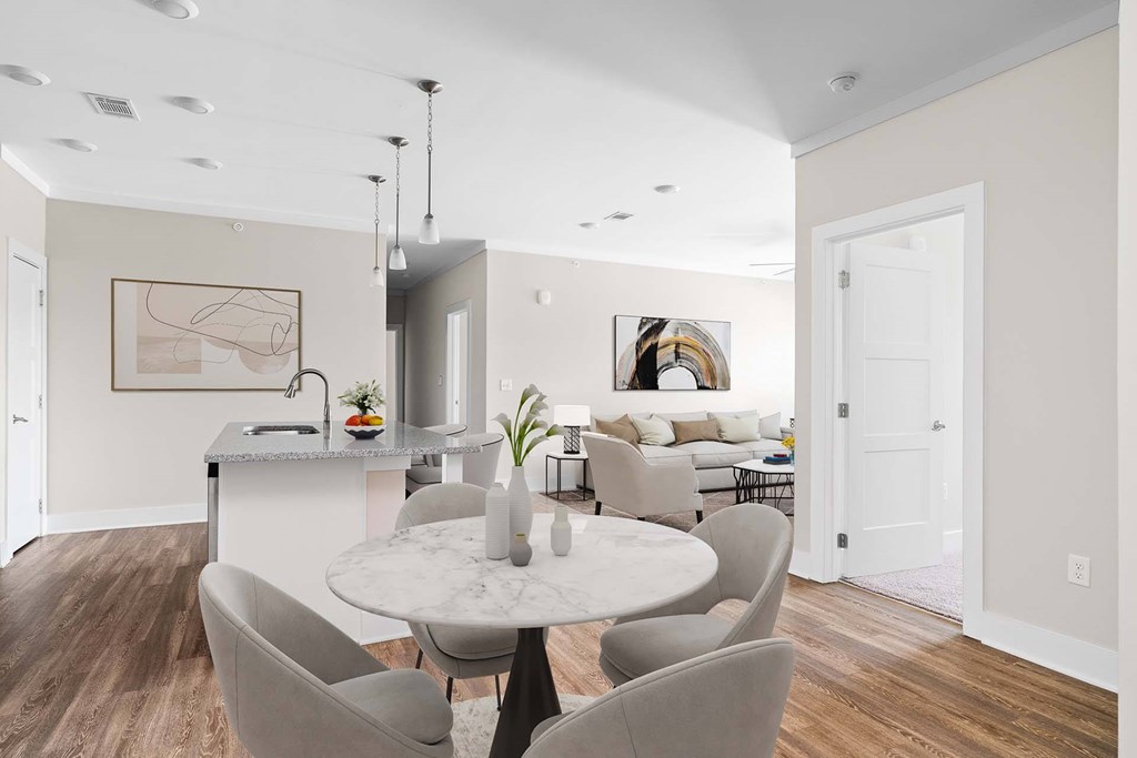 A modern dining room with a marble table and grey chairs.