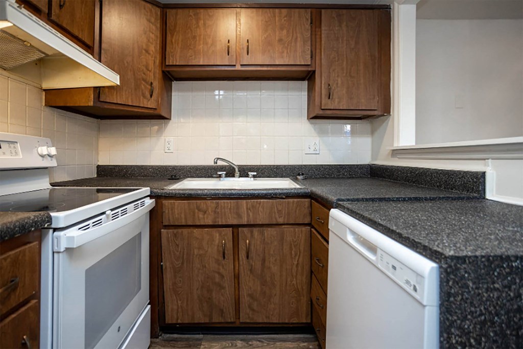 a kitchen with white appliances and brown cabinets