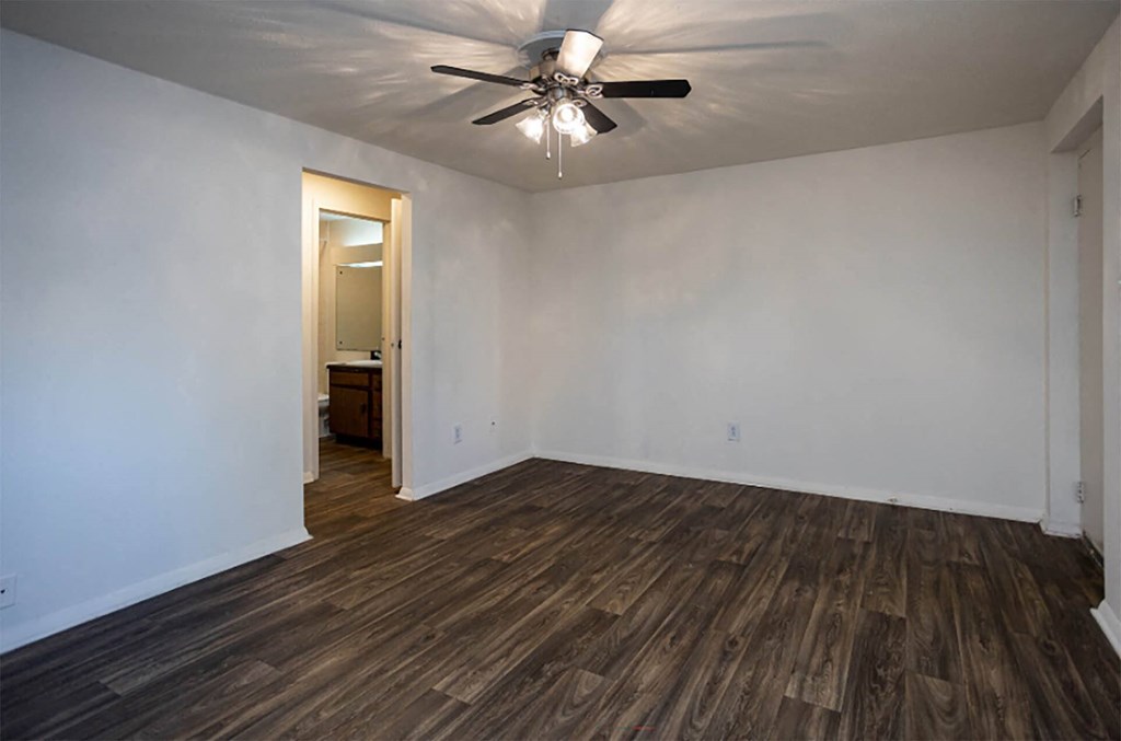 a living room with white walls and a ceiling fan