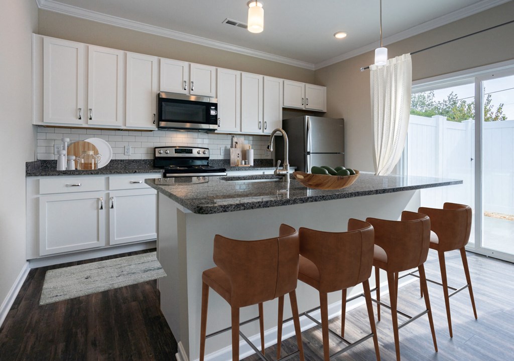 a kitchen with white cabinets and a counter with bar stools