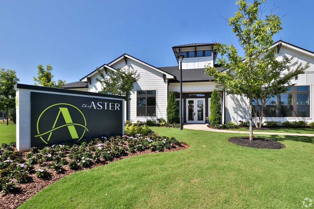 A sign for ASTER in front of a building.