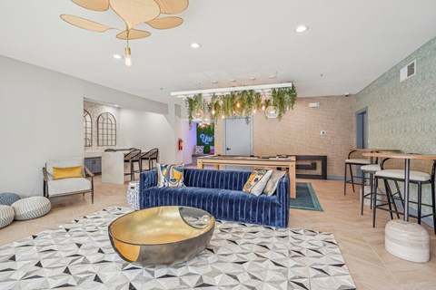 A living room with a blue couch and a gold bowl on the floor.