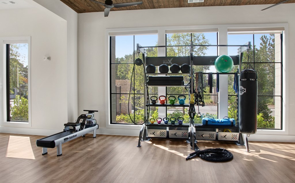 a home gym with ample windows and wood flooring