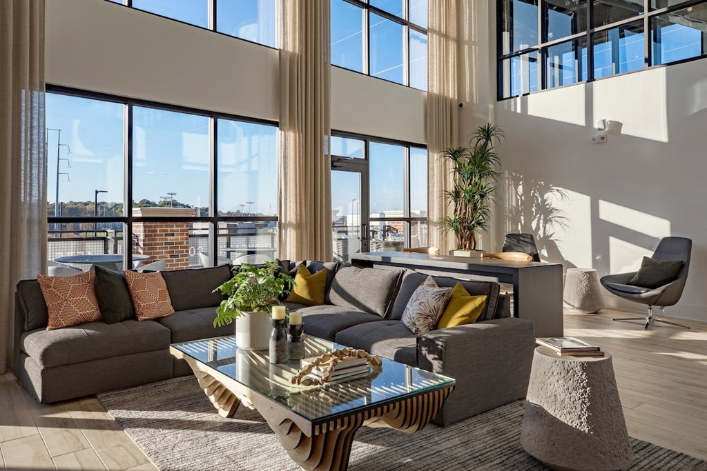a living room with large windows and a couch and a table